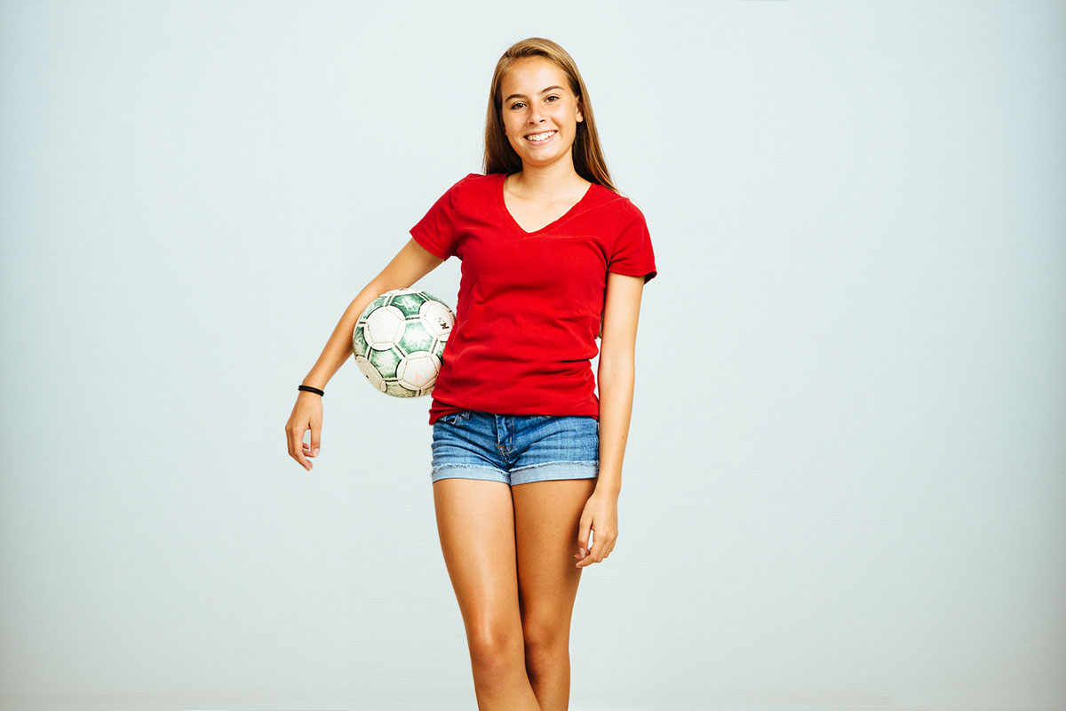 teen girl holding soccer ball
