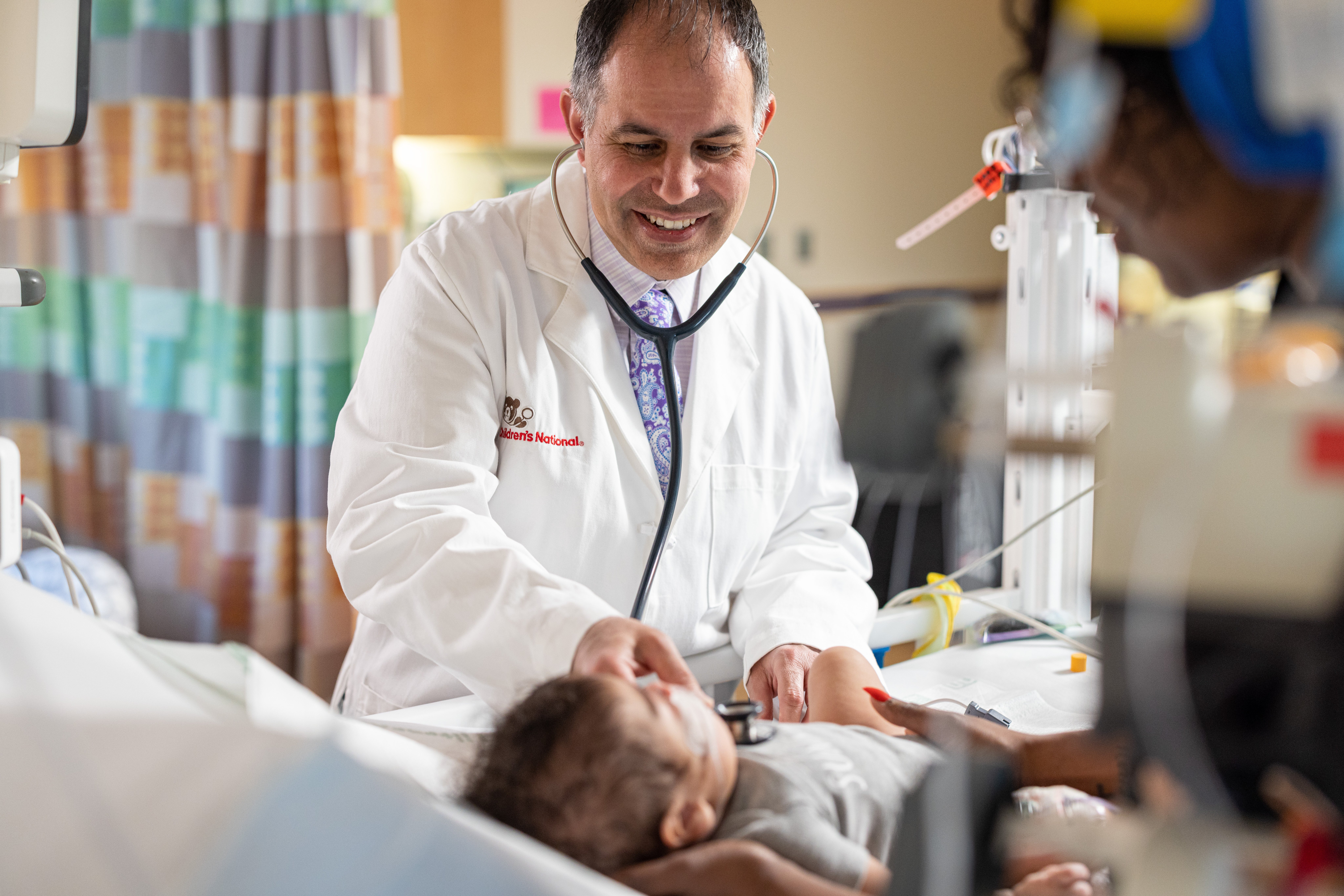 Pediatric cardiologist, Ashraf Saud Harahsheh, M.D, checks a patient’s pulse.