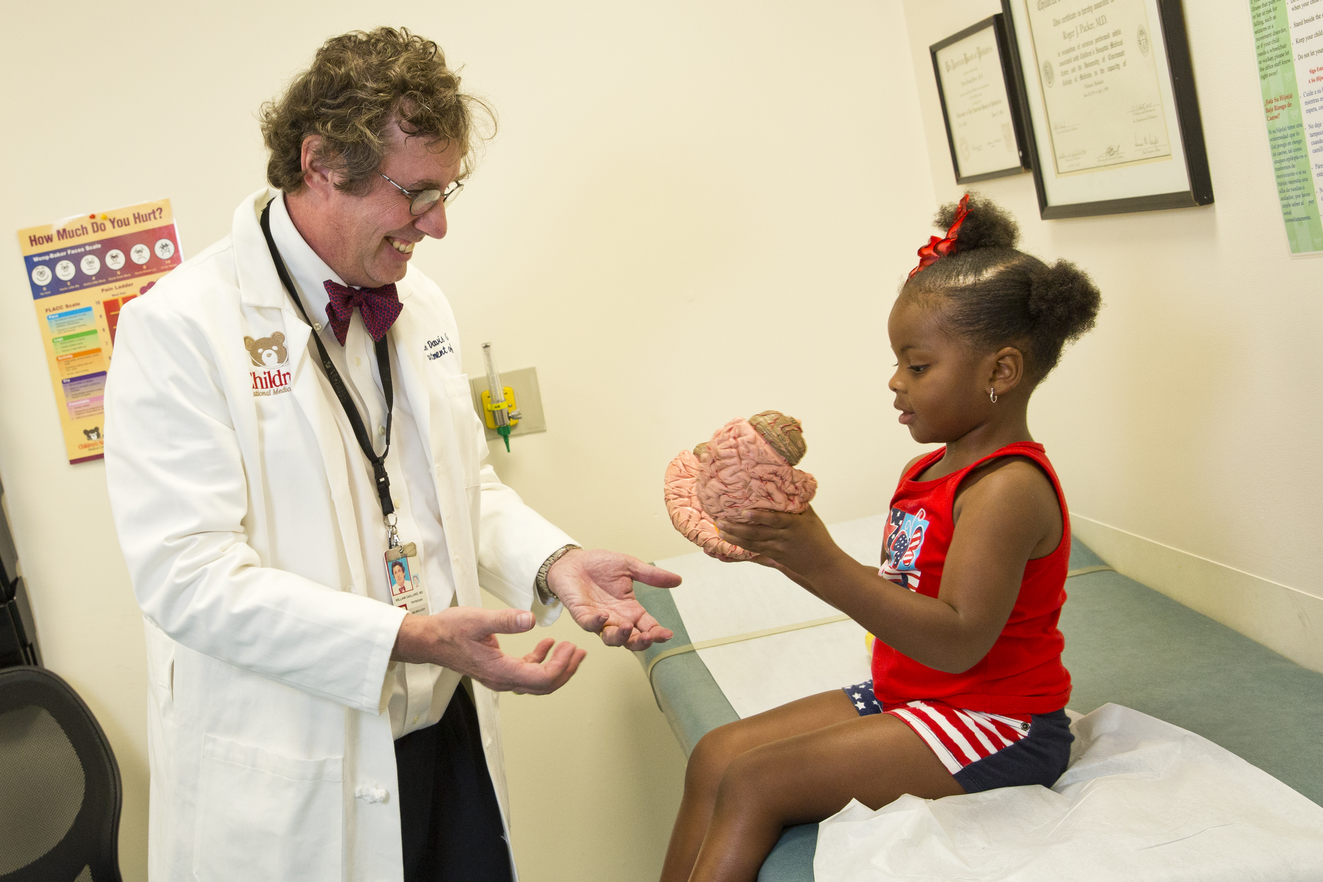 Dr. Gaillard showing young girl a model brain