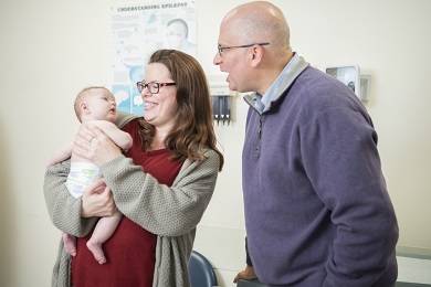 Dr. Marc Levitt smiles at a baby in her mother's arms.