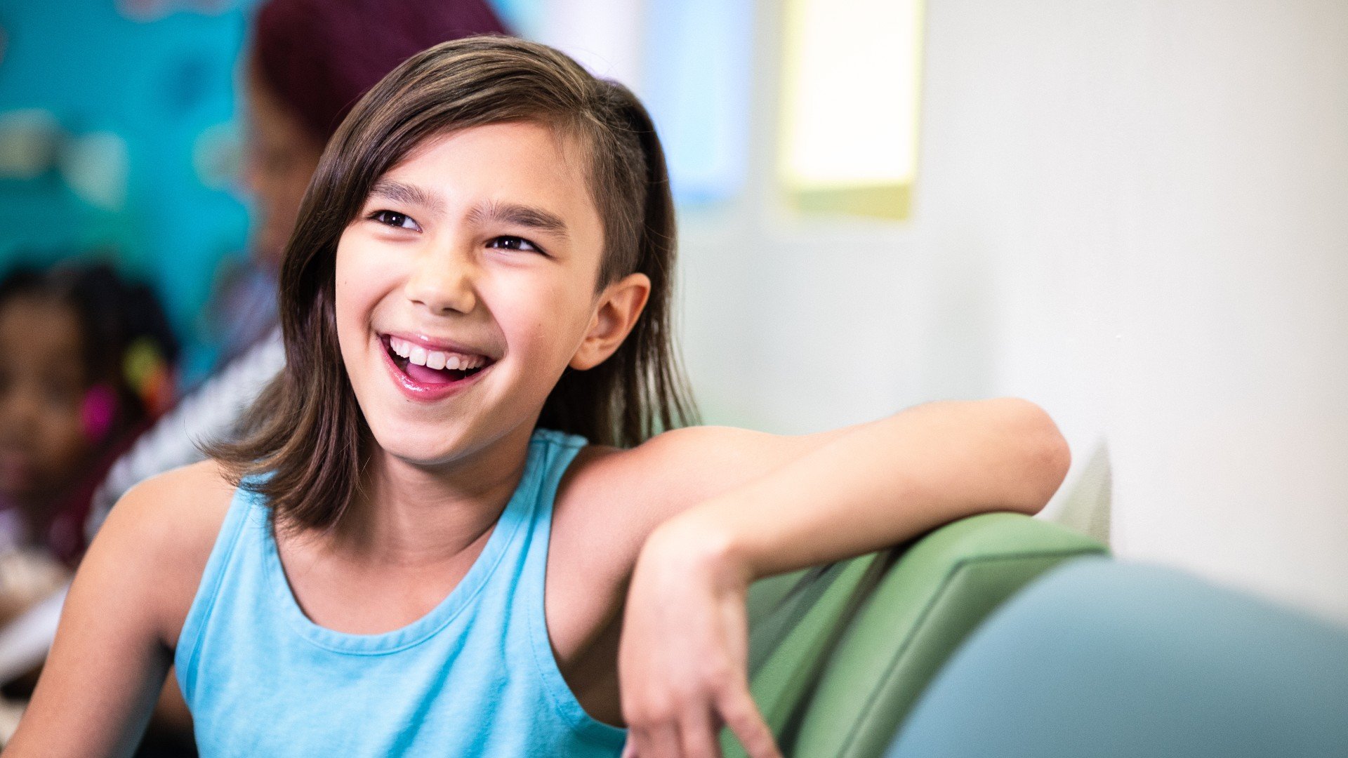 A young girl smiles in the waiting room of the Division Endocrinology and Diabetes.