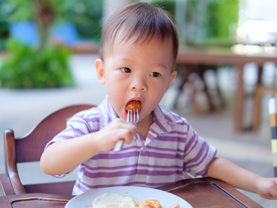 little boy eating tomatoes