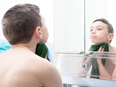 teen boy washing his face