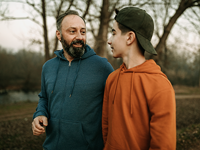 father talking to teen son outside 
