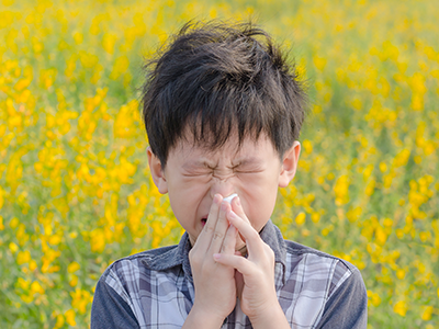 little boy with allergies in field of flowers