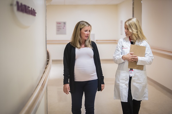 Catherine Limperopoulos, Ph.D., walks down a hallway at Children's National Hospital with an expectant mother.