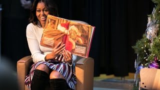 First Lady Michelle Obama in 2014 displays book to her young listeners
