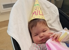 Baby Mila in her stoller with a Happy New Year hat. 