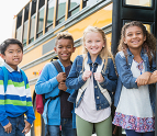 School children standing outside of a bus