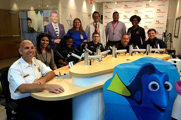 Members of the Children's National Emergency Medical Services for Children Program and D.C. FEMS sit at a table in Seacrest Studios in our main hospital.