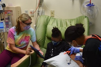 Child life specialist with boy getting blood drawn
