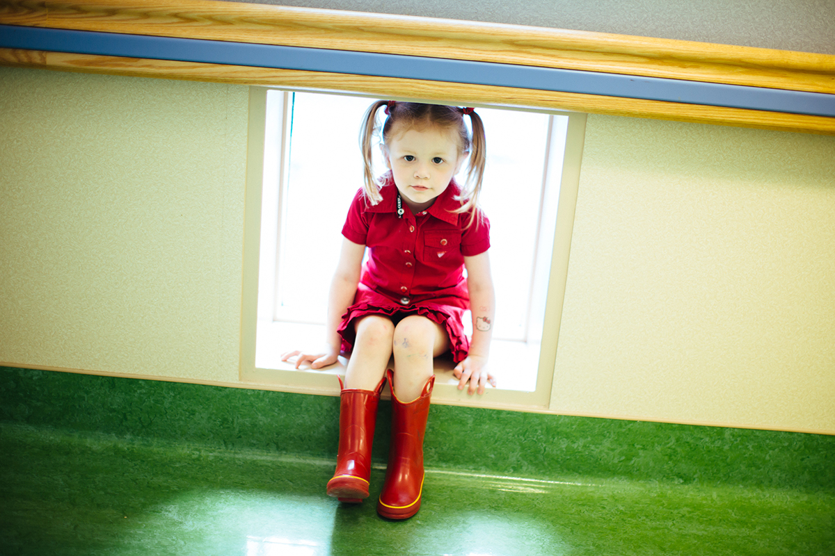 girl sitting with red dress and rainboots