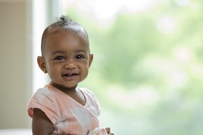 Toddler girl in peach top smiling