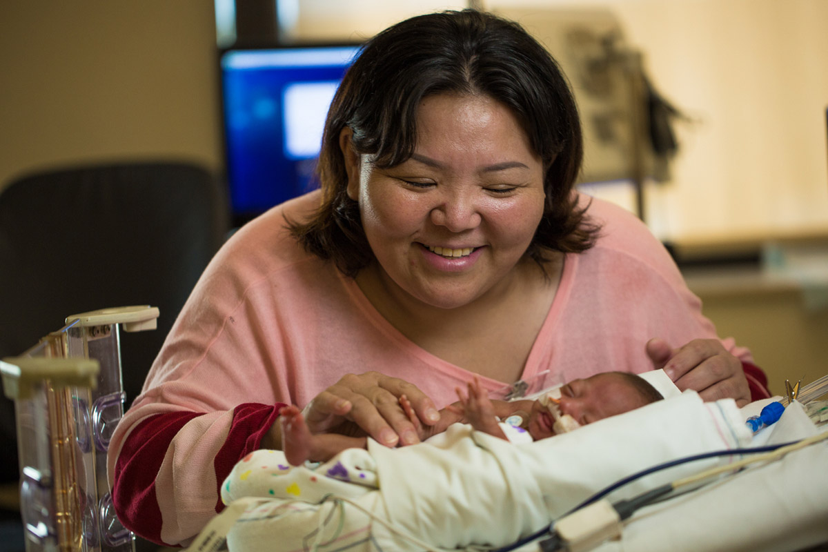 mother caring for premature baby in children's hospital NICU