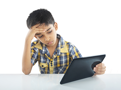boy with a headache looking at a tablet