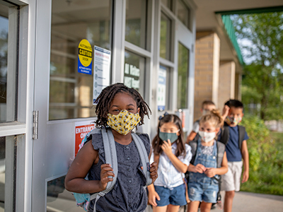 masked kids waiting in line for school